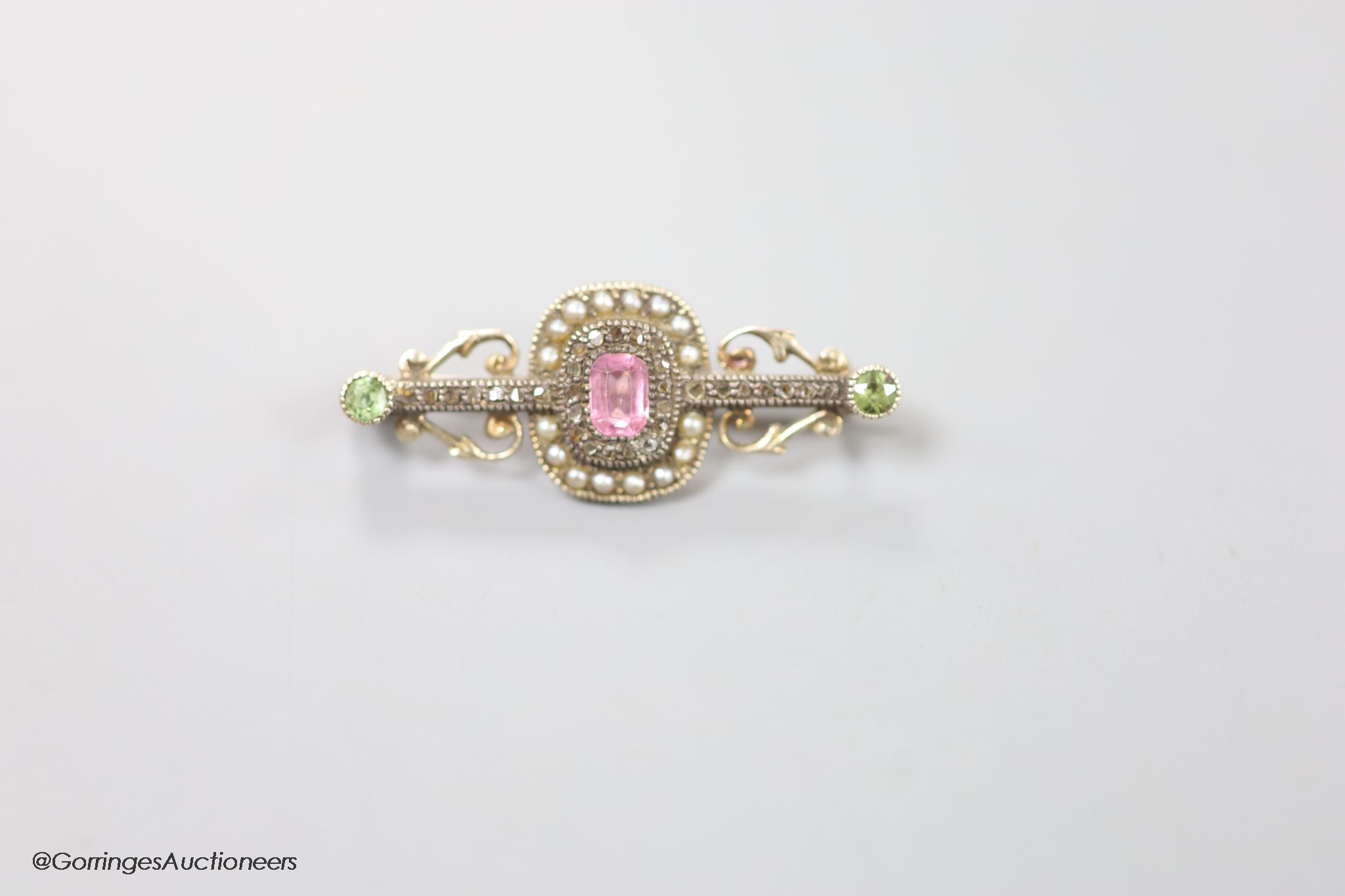 A late Victorian yellow metal, pink spinel?, green garnet, seed pearl and rose cut diamond set bar brooch, 35mm, gross weight 4.2 grams.